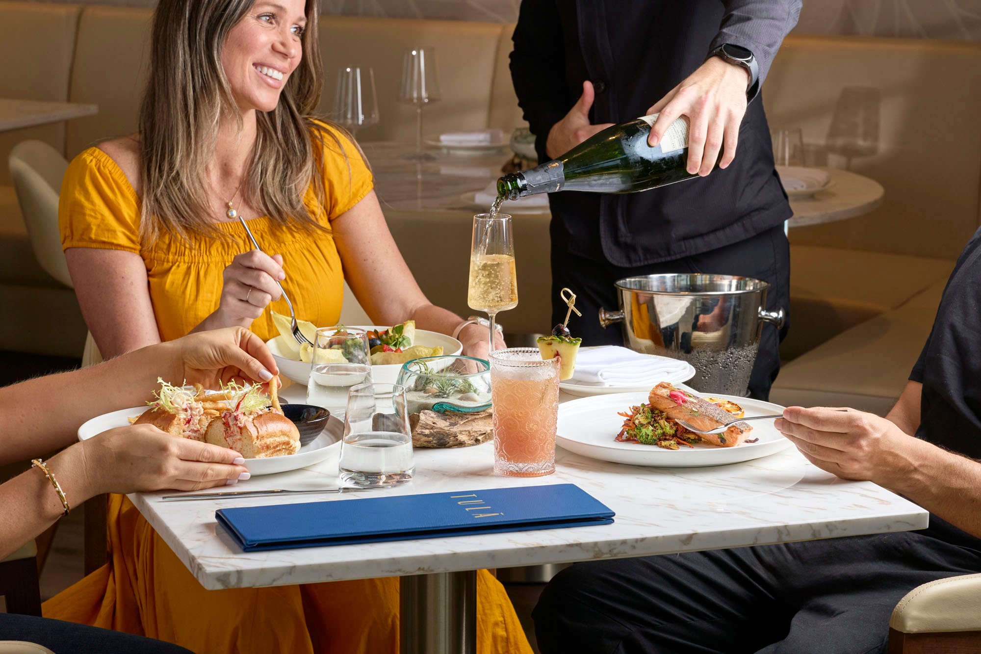 3 people eating an assortment of food and having an assortment of drinks at Tula