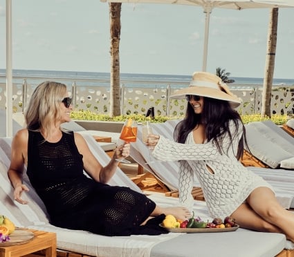 Two women lounging at the Amrit Ocean Resort drinking some cocktails