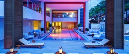 The Aayush pool in the evening with ambient pink and violet lighting at Amrit Ocean Resort.