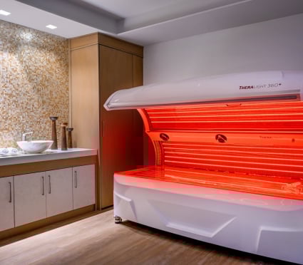 A TherLight spa treatment lit up with red light at Amrit Ocean Resort.