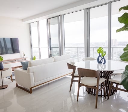 The dining space, living space, and floor to ceiling views of Riviera Beach, Florida in an intracoastal View Wellness Residence at the Amrit Ocean Resort
