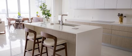 The dining space, floor to ceiling views of Riviera Beach, Florida, and the kitchen in an intracoastal View Wellness Residence at the Amrit Ocean Resort