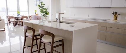 The dining space, floor to ceiling views of Riviera Beach, Florida, and the kitchen in an intracoastal View Wellness Residence at the Amrit Ocean Resort