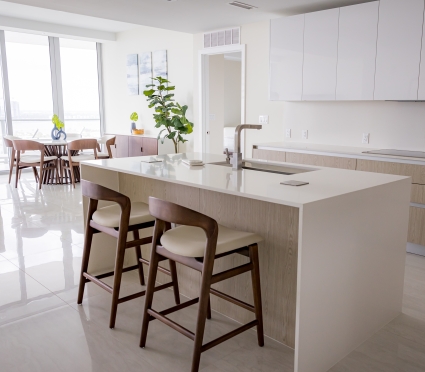 The dining space, floor to ceiling views of Riviera Beach, Florida, and the kitchen in an intracoastal View Wellness Residence at the Amrit Ocean Resort
