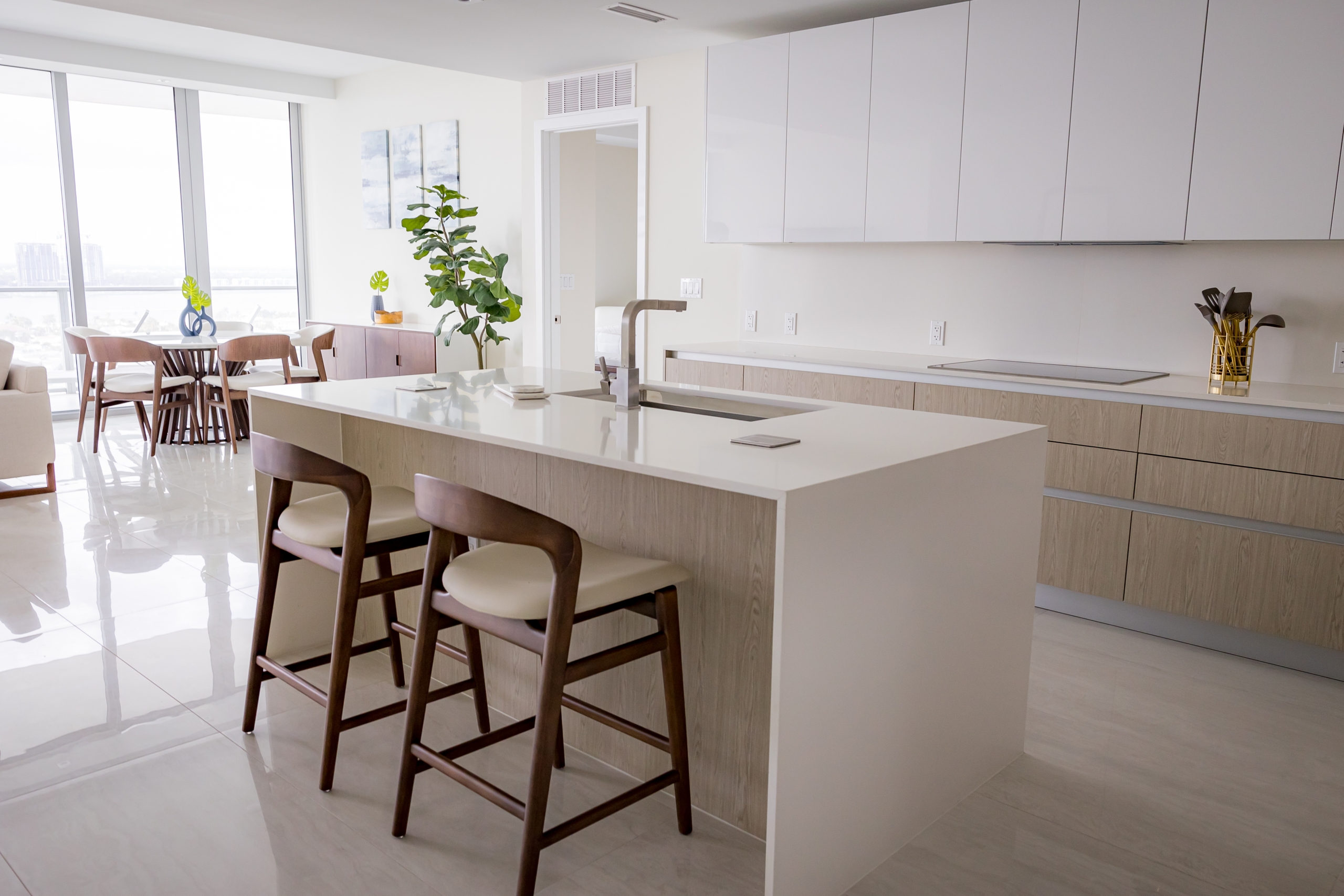 The dining space, floor to ceiling views of Riviera Beach, Florida, and the kitchen in an intracoastal View Wellness Residence at the Amrit Ocean Resort