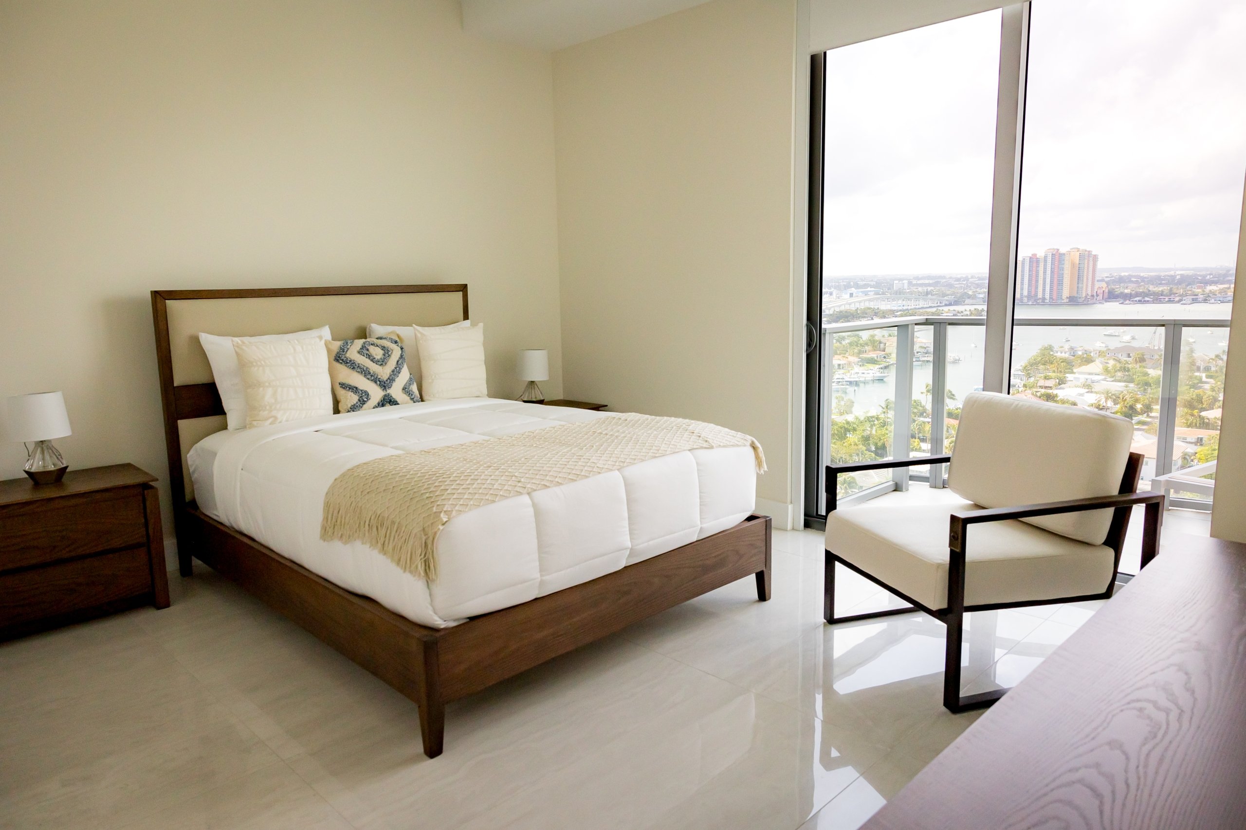 The bedroom with a queen bed and floor to ceiling views of Riviera Beach, Florida in an intracoastal View Wellness Residence at the Amrit Ocean Resort