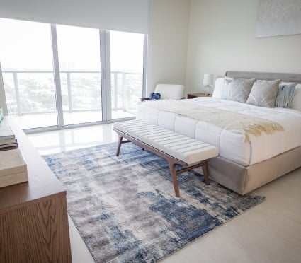 The bedroom with a queen bed and floor to ceiling views of Riviera Beach, Florida in an intracoastal View Wellness Residence at the Amrit Ocean Resort