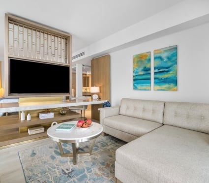 Living area with a large TV and view to the room of an ocean view king room at Amrit Ocean Resort