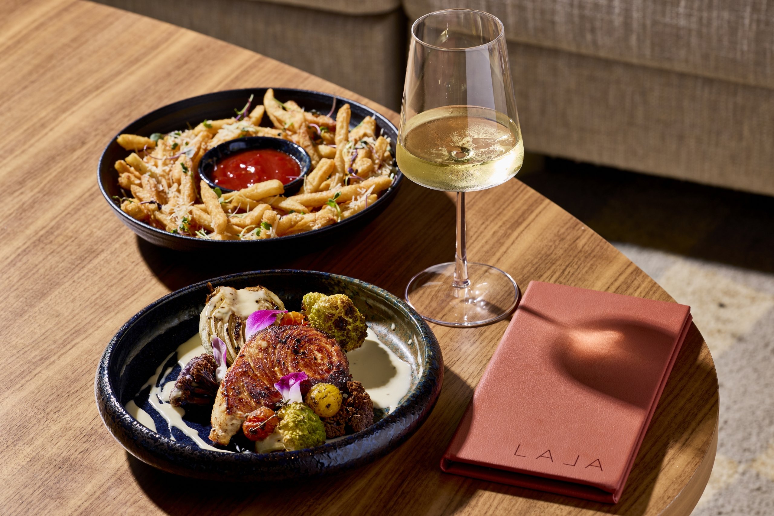 Fish, veggies, fries, and a glass of white wine at LALA