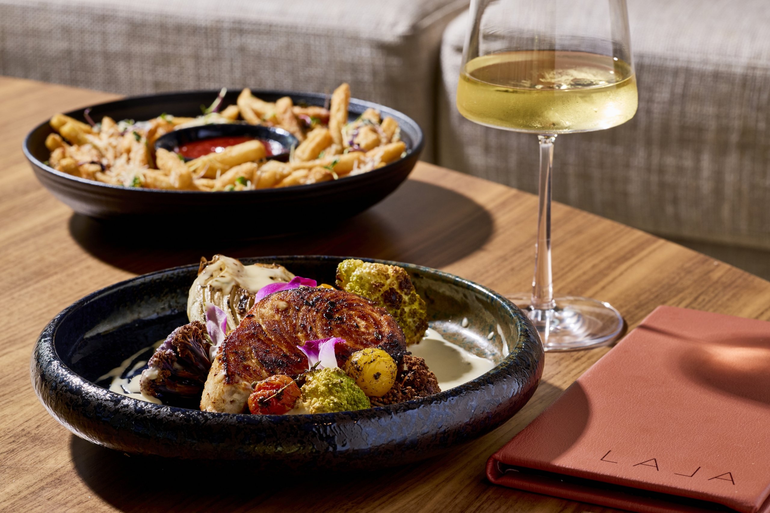 Fish, veggies, fries, and a glass of white wine at LALA