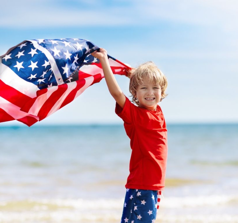 Boy on the beach with USA flag at Amrit Ocean Resort