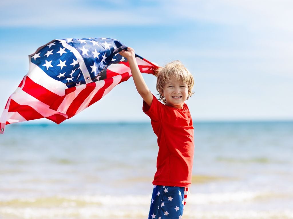 Boy on the beach with USA flag at Amrit Ocean Resort