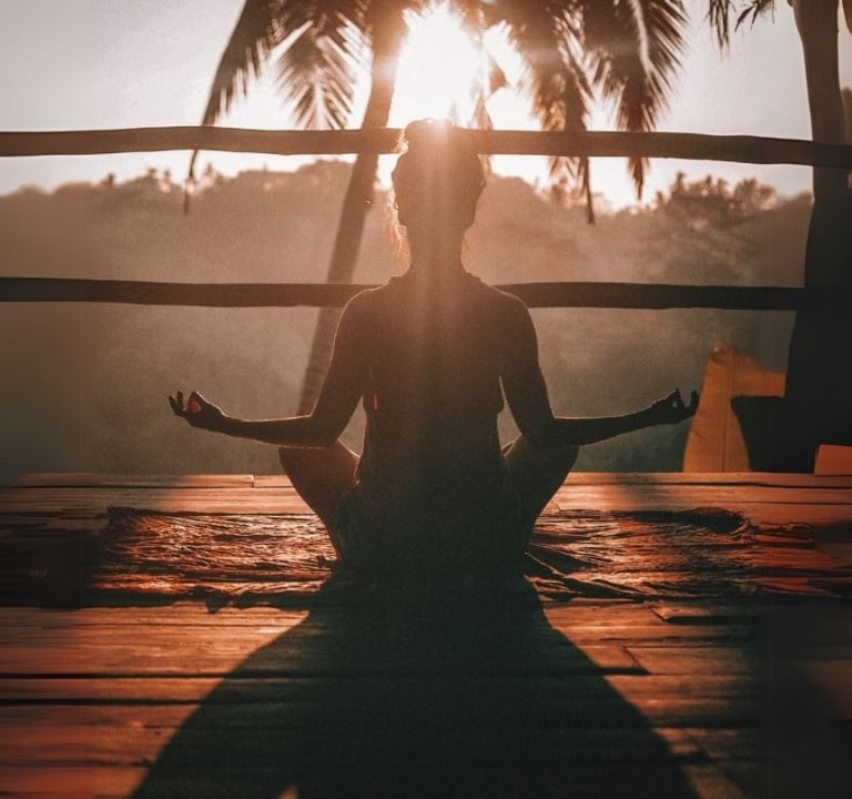 Lady doing yoga in front of sunset at Amrit ocean resort