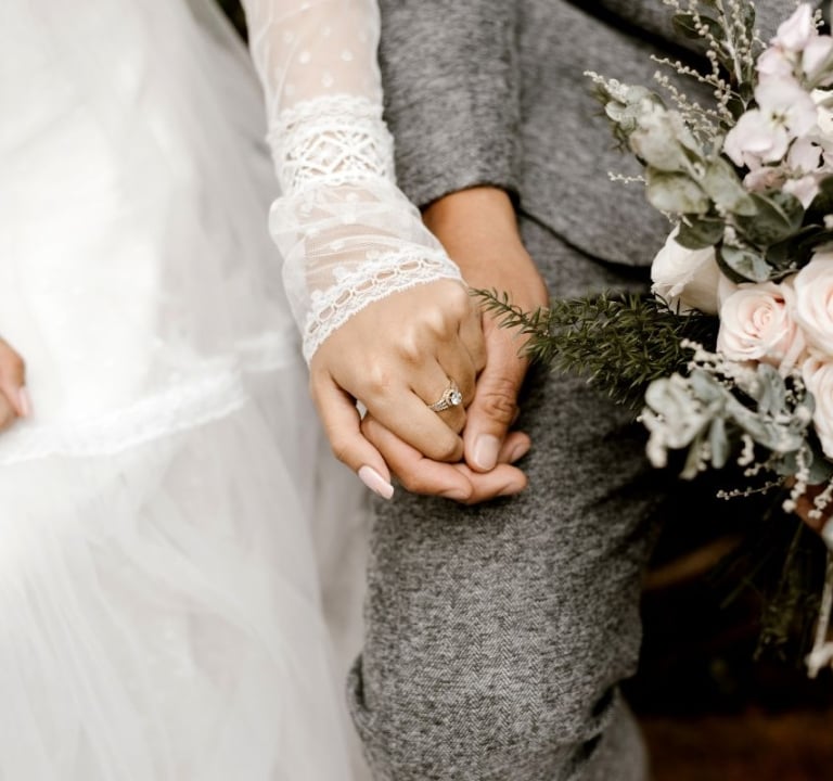Close-up of an engaged hand with diamond ring during beach wedding at Amrit Ocean Resort